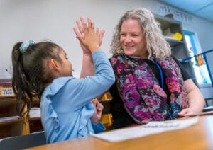 SEN support for children UK — teacher helping a neurodiverse child in a classroom